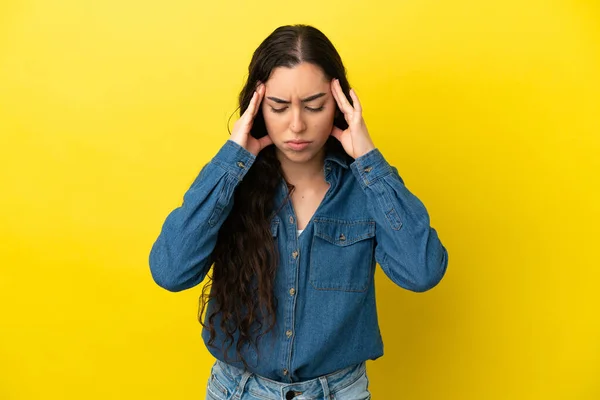 若い白人女性は頭痛の種で黄色の背景に隔離されました — ストック写真