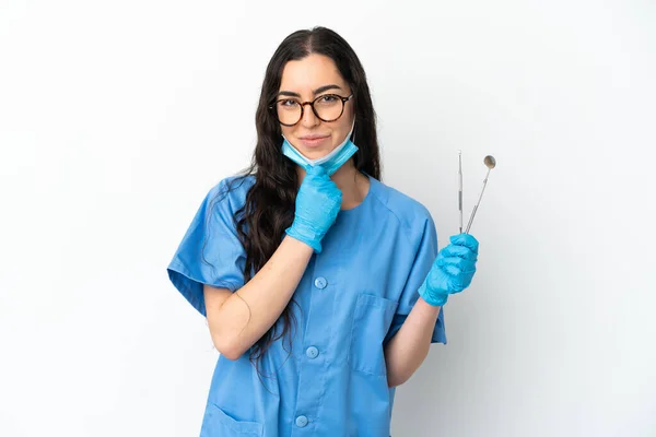 Młoda Kobieta Dentysta Gospodarstwa Narzędzia Izolowane Białym Tle Myślenia — Zdjęcie stockowe