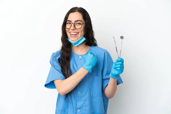 年轻的女牙医拿着被白色背景隔离的工具庆祝胜利 — 图库照片