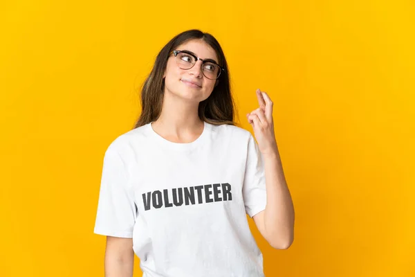 Mujer Joven Voluntaria Aislada Sobre Fondo Amarillo Con Dedos Cruzando — Foto de Stock