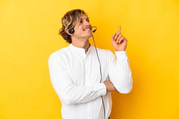 Telemarketer Człowiek Pracuje Słuchawki Izolowane Żółtym Tle Wskazując Świetny Pomysł — Zdjęcie stockowe