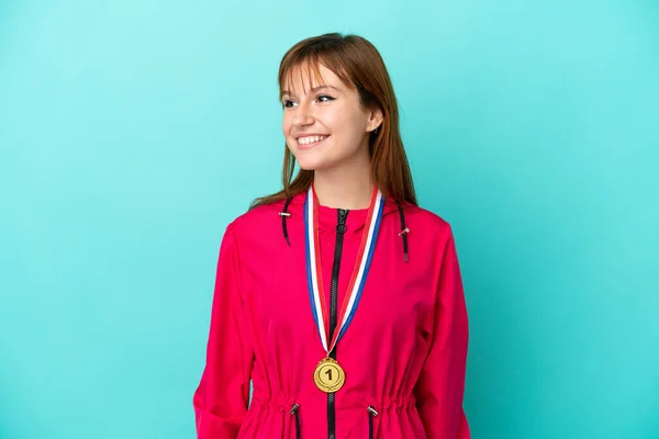 Pelirroja Chica Con Medallas Aisladas Fondo Azul Mirando Lado —  Fotos de Stock