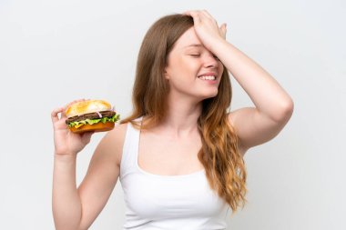 Beyaz arka planda izole edilmiş bir burger tutan genç ve güzel bir kadın bir şeyin farkına vardı ve çözüme niyetlendi.