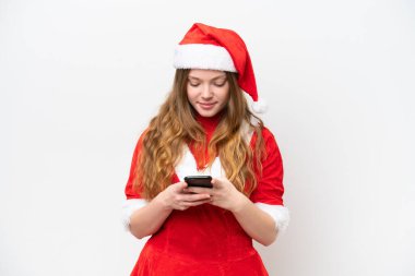 Beyaz arka planda izole edilmiş beyaz elbiseli beyaz bir kadın cep telefonuyla bir mesaj gönderiyor.