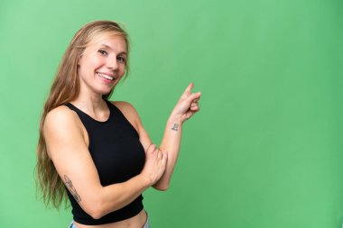 Izole arka plan tarafında parmak işaret üzerinde genç sarışın kadın