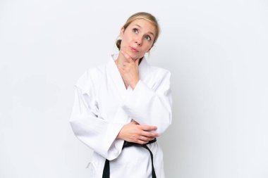 Beyaz arka planda karate yapan beyaz bir kadın var.