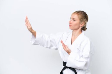 Beyaz arka planda karate yapan beyaz tenli genç kadın.