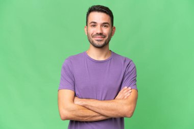 Soyutlanmış geçmişi olan yakışıklı beyaz bir adam kollarını ön cephede kavuşturuyor.