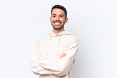 Beyaz arka planda izole edilmiş, kolları çapraz ve ileriye bakan genç beyaz bir adam.