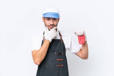 Kasap beyaz önlük takmış ve izole edilmiş beyaz arka planda taze et servis ediyor.