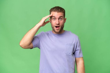 Yeşil krom arka planda yaşayan yakışıklı beyaz adam bir şey fark etti ve çözüme niyetlendi.