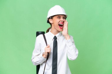 Miğferli genç bir mimar kadın izole edilmiş arka planda planları tutuyor ve ağzı sonuna kadar açık bağırıyor.