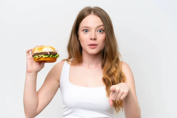 Young Pretty Woman Holding Burger Isolated White Background Surprised Pointing — Stock Photo, Image