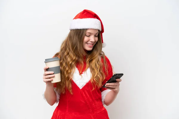 年轻的高加索女人 穿着白色背景的圣诞礼服 手里拿着咖啡和手机 — 图库照片