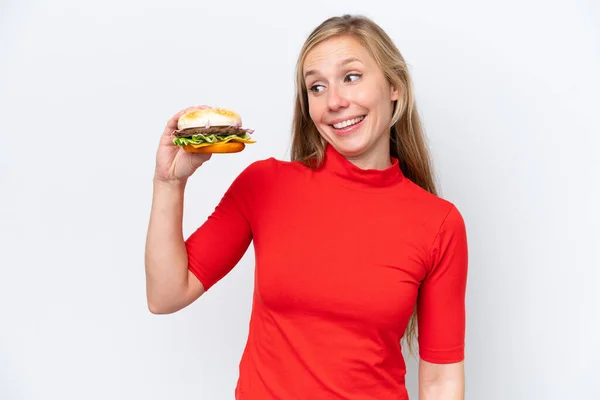 Młoda Blondynka Trzyma Hamburgera Białym Tle Szczęśliwym Wyrazem Twarzy — Zdjęcie stockowe