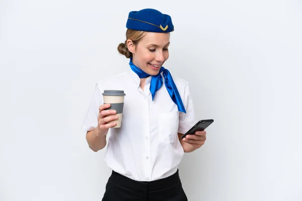 飛行機ブロンドスチュワーデス女性隔離オンホワイト背景保持コーヒーに取り去るとモバイル — ストック写真