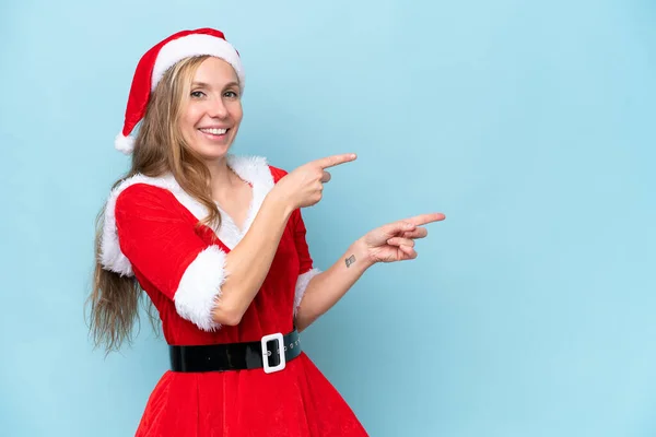 Jovem Loira Vestida Como Mama Claus Isolado Fundo Azul Apontando — Fotografia de Stock