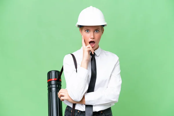 Junge Architektin Mit Helm Und Bauplänen Vor Isoliertem Hintergrund Überrascht — Stockfoto