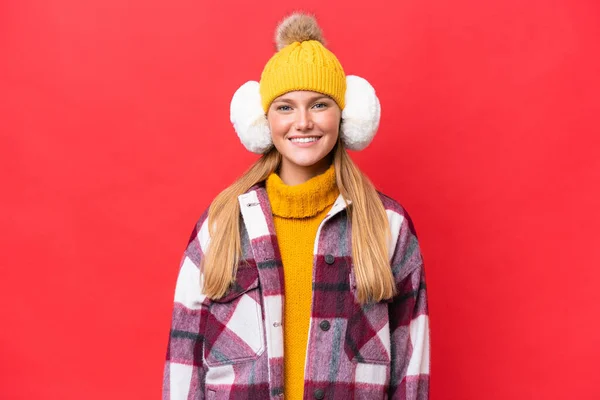 Junge Schöne Frau Trägt Wintermuffs Isoliert Auf Rotem Hintergrund Lachend — Stockfoto