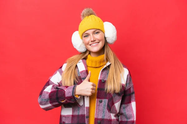 Young Beautiful Woman Wearing Winter Muffs Isolated Red Background Giving — Stock Photo, Image