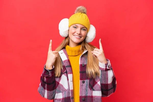 Junge Schöne Frau Trägt Wintermuffs Isoliert Auf Rotem Hintergrund Weist — Stockfoto