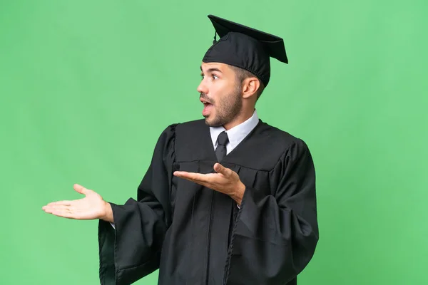 Fiatal Egyetemi Diplomás Férfi Elszigetelt Háttér Meglepetés Arckifejezés — Stock Fotó