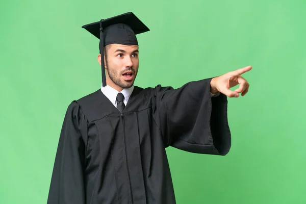 Fiatal Egyetemi Diplomás Férfi Elszigetelt Háttér Mutatva — Stock Fotó