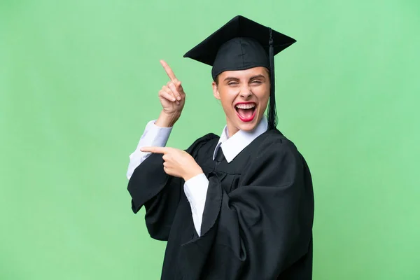 Junge Universitätsabsolventin Aus Kaukasien Über Isolierten Hintergrund Zeigt Mit Dem — Stockfoto