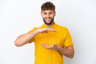 Beyaz arka planda izole edilmiş beyaz, yakışıklı beyaz bir adam bir ilan vermek için avuç içinde hayali bir fotokopi makinesi tutuyor.