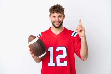 Beyaz arka planda ragbi oynayan beyaz bir adam harika bir fikre işaret ediyor.