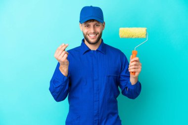 Kafkasyalı ressam mavi arka planda izole edilmiş para hareketi yapıyor.