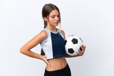 Beyaz arka planda izole edilmiş futbol oynayan küçük beyaz kız çaba sarf ettiği için sırt ağrısı çekiyor.