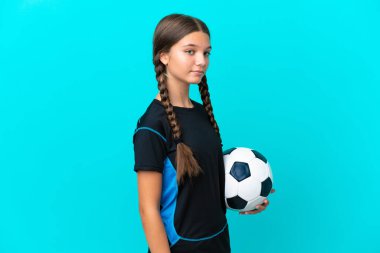 Mavi arka planda, futbol topuyla izole edilmiş küçük beyaz kız.