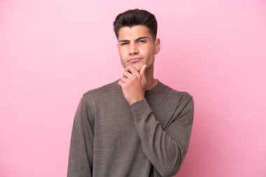 Pembe arka planda soyutlanmış beyaz bir adam.