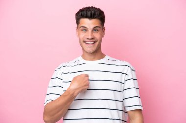 Pembe arka planda yalıtılmış beyaz bir adam. Şaşırtıcı bir yüz ifadesi var.