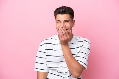 Pembe arka planda izole edilmiş genç beyaz adam mutlu ve gülümsüyor.