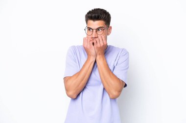 Beyaz arka planda izole edilmiş genç beyaz bir adam gergin ve korkmuş bir şekilde elleriyle suni teneffüs yapıyor.
