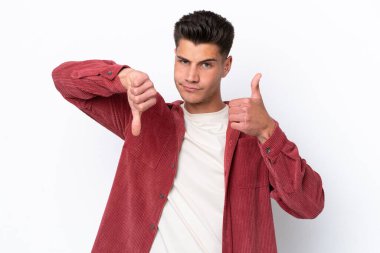 Beyaz arka planda izole edilmiş beyaz bir adam iyiye-kötüye işaret yapıyor. Evet ya da hayır arasında kararsız