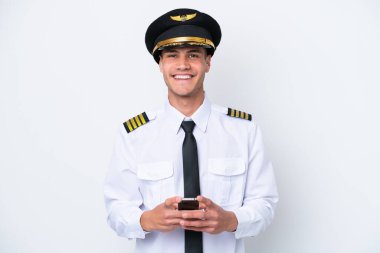 Airplane caucasian pilot isolated on white background sending a message with the mobile