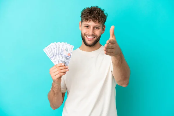 Jonge Kaukasische Man Neemt Veel Geld Geïsoleerd Blauwe Achtergrond Handen — Stockfoto