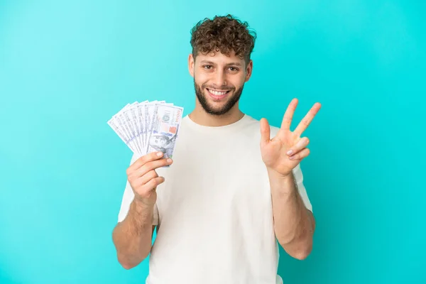 Νεαρός Καυκάσιος Παίρνει Πολλά Χρήματα Απομονωμένος Μπλε Φόντο Ευτυχισμένος Και — Φωτογραφία Αρχείου