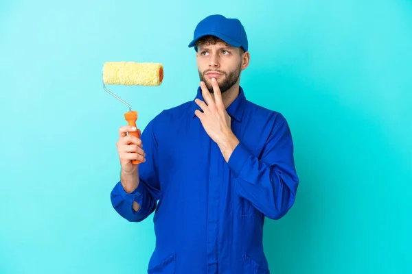 Pintor Caucásico Aislado Sobre Fondo Azul Teniendo Dudas Mientras Mira — Foto de Stock
