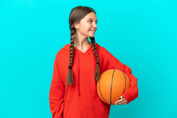 Piccola Ragazza Caucasica Giocare Basket Isolato Sfondo Blu Cercando Lato — Foto Stock