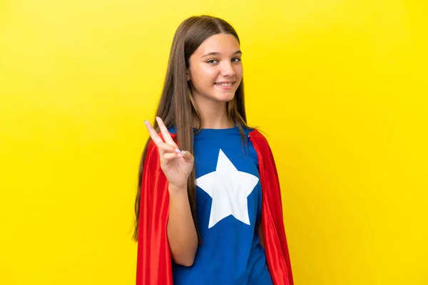 小さなCaucasianスーパーヒーロー女の子絶縁上の黄色の背景笑顔とショー勝利のサイン — ストック写真
