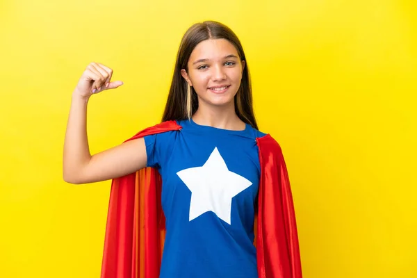 小さなCaucasianスーパーヒーロー女の子絶縁上の黄色の背景あります強いジェスチャー — ストック写真