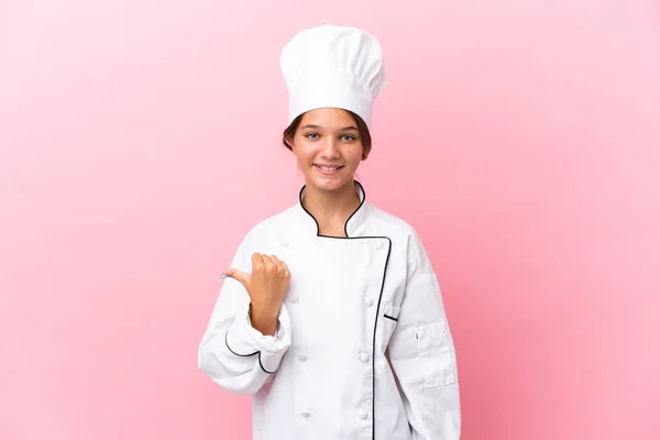 Pequena Menina Chef Caucasiano Isolado Fundo Rosa Apontando Para Lado — Fotografia de Stock