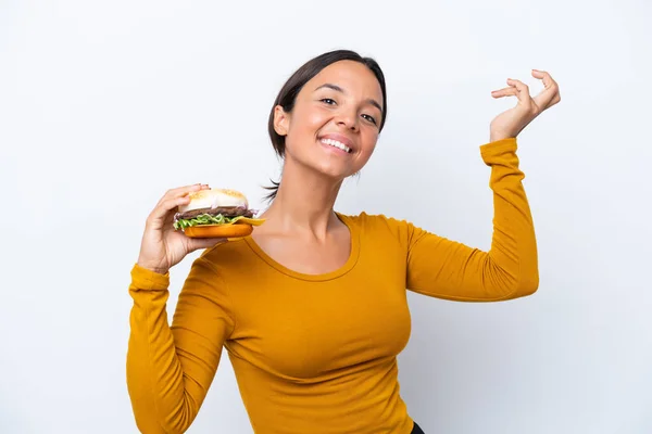 Młoda Latynoska Kobieta Trzyma Hamburgera Białym Tle Wyciągając Ręce Bok — Zdjęcie stockowe