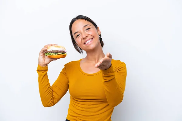Młoda Latynoska Kobieta Trzyma Hamburgera Odizolowanego Białym Tle Ściskając Dłonie — Zdjęcie stockowe