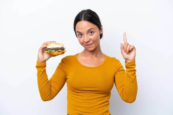 Młoda Latynoska Kobieta Trzyma Hamburgera Odizolowanego Białym Tle Pokazując Podnosząc — Zdjęcie stockowe