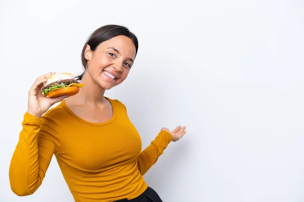 Młoda Latynoska Kobieta Trzyma Hamburgera Białym Tle Wyciągając Ręce Bok — Zdjęcie stockowe